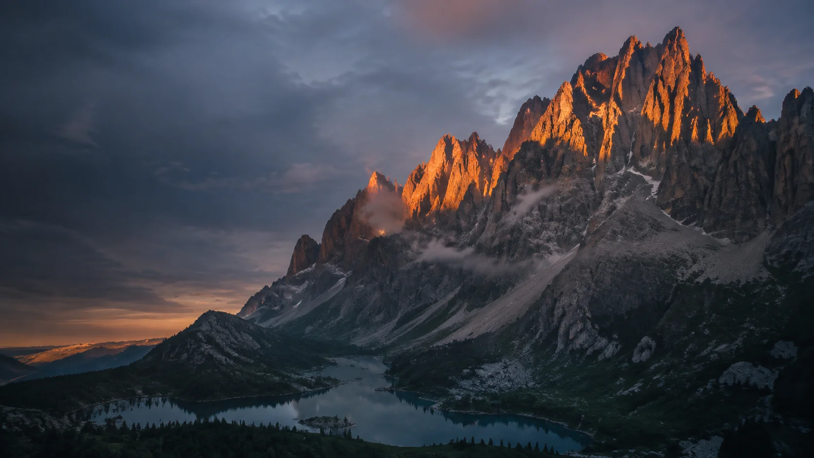 Sunset lights towering alpine peaks above a still mountain lake.